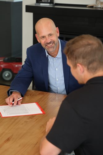 Aaron Hatanpa smiling and meeting with a team member